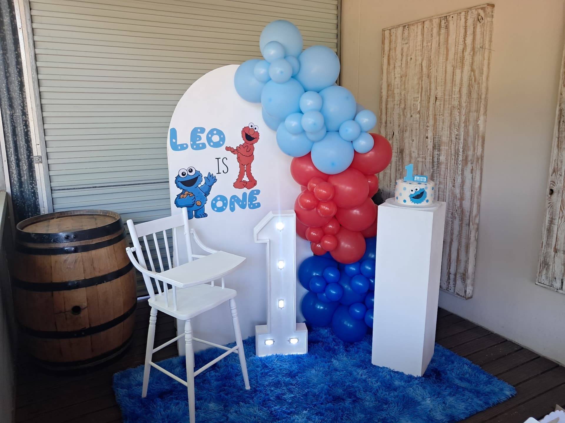 Sesame Street themed 1st birthday party setup with blue and red balloons