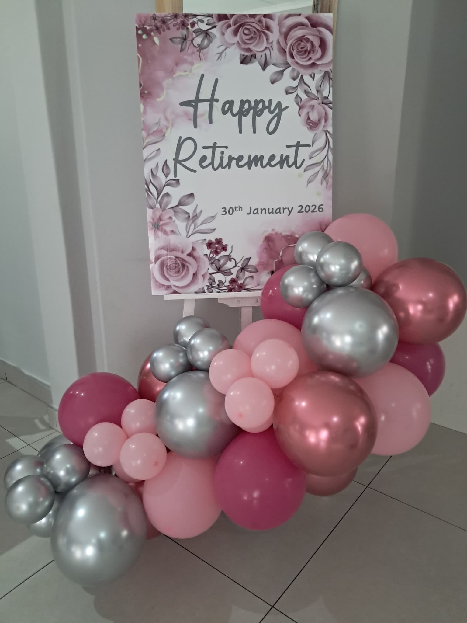 Happy Retirement party sign with pink and silver balloon arrangement
