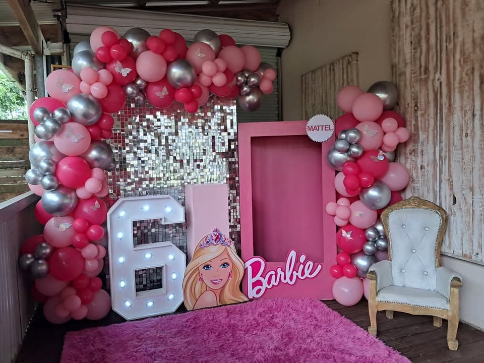 Barbie themed 6th birthday party with pink balloons, shimmer wall and Barbie photo frame