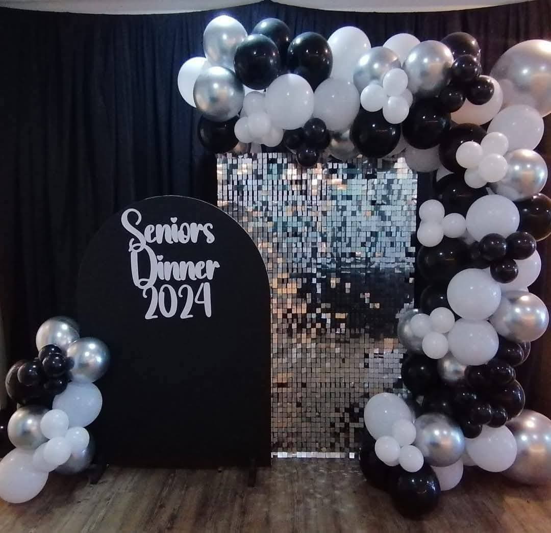Seniors Dinner 2024 black and silver balloon arch with sequin shimmer wall